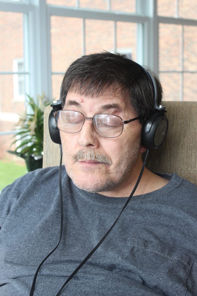 A resident in the Music & Memory program listening to music with headphones on