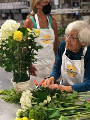 A resident putting together a floral arrangement