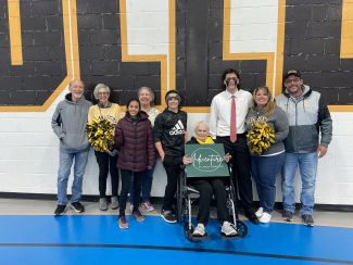 A grandmother posing with her family after her grandson's college lacrosse game at Adrian College