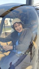 A resident sitting in a helicopter, smiling