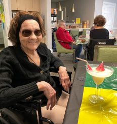 A resident smiling and enjoying her pina colada in Jamaica