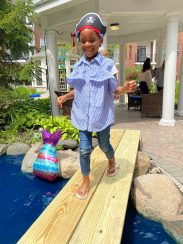 A camper smiling as she "walks the plank"