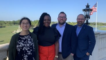 Panelists pose for a photo outside