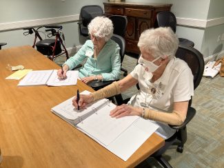 Two residents doing simple math exercises at a table together