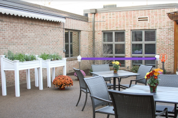 There are tables and gardening planters in Asper Courtyard