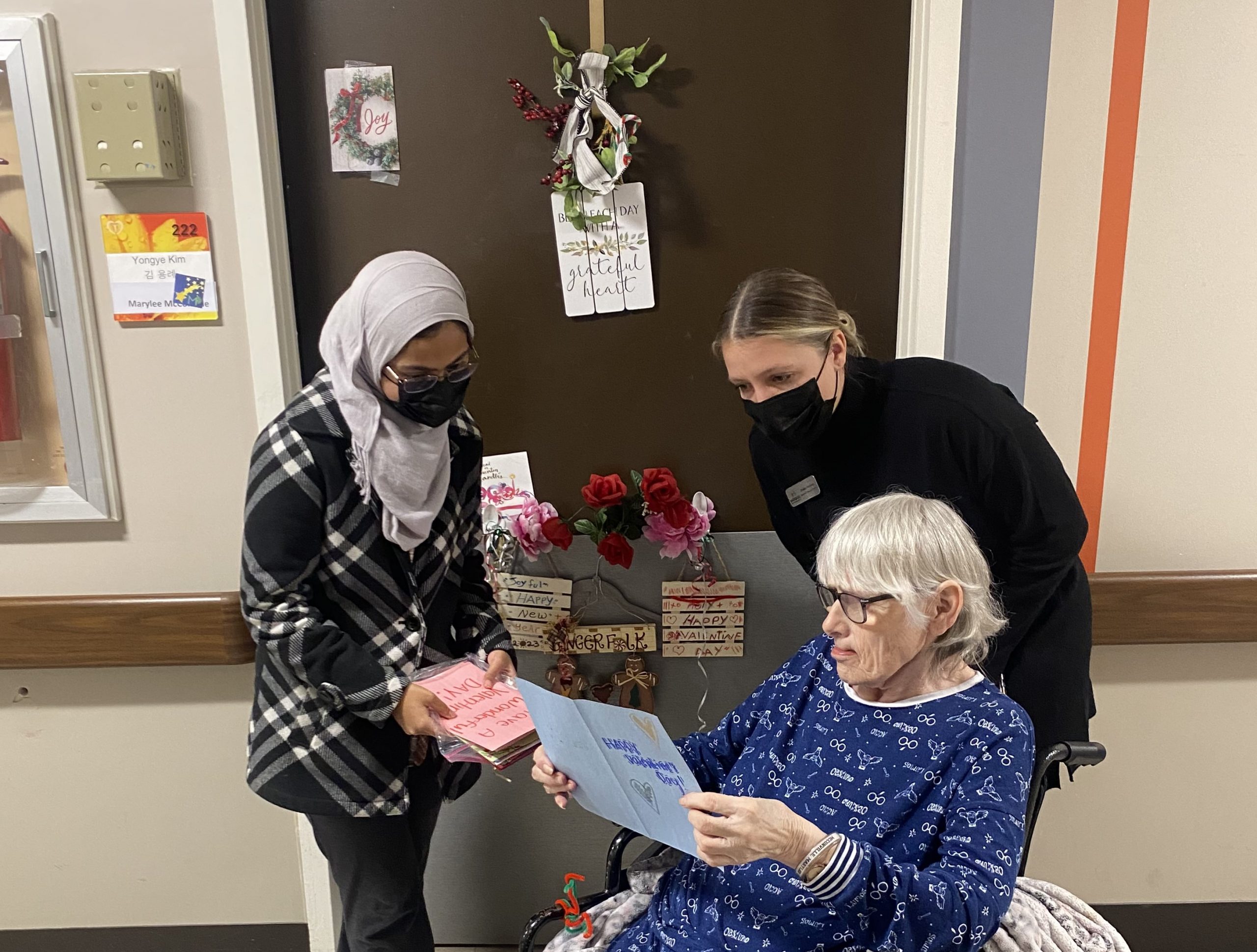 Resident reads a Letters for Rose letter with a high school student and Saracen