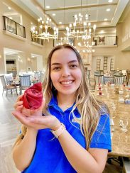 A culinary team member holding a napkin in the shape of a rose