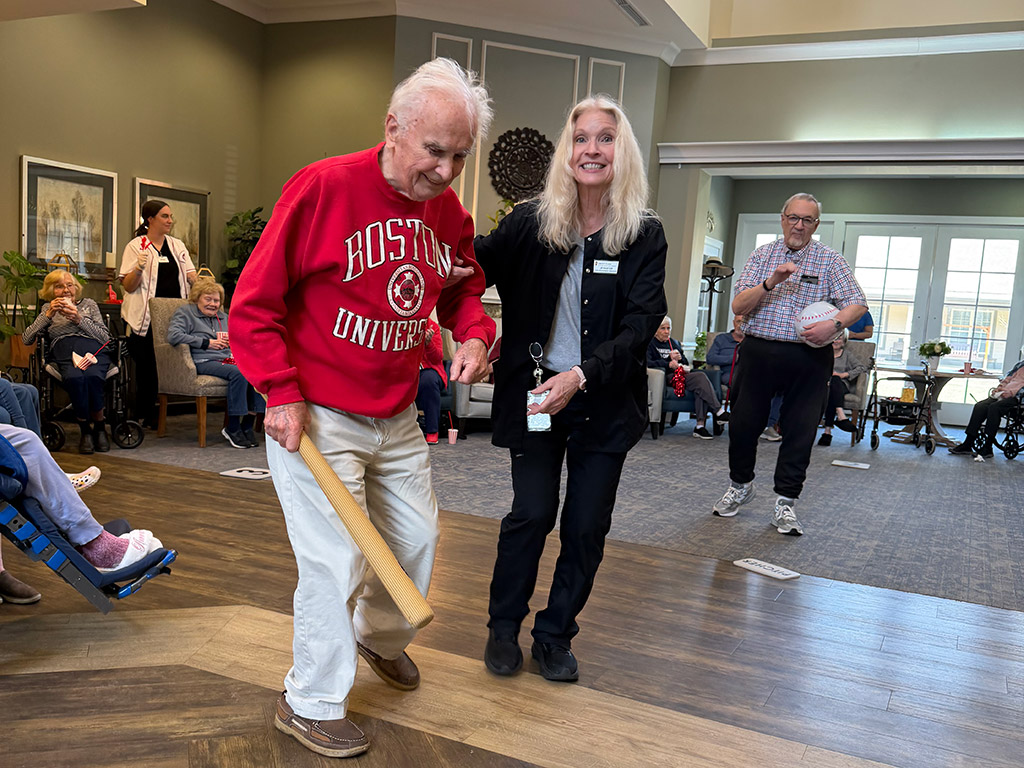 : Liberty Place resident Paul Aniskovich runs the bases with the help of Jen Phillips, life engagement assistant.