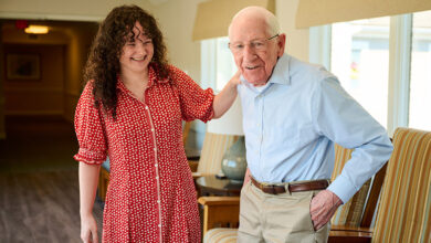 Associate Riley Finnegan, left, talks with resident John Tincler at New Pond Village.