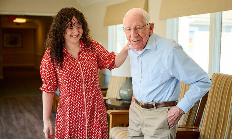 Associate Riley Finnegan, left, talks with resident John Tincler at New Pond Village.